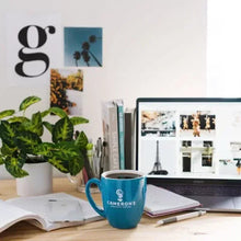 Cameron's coffee mug with brewed coffee on desk near laptop and notes