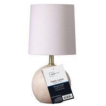 Mini table lamp with light fabric shade, textured ball base, and product tag