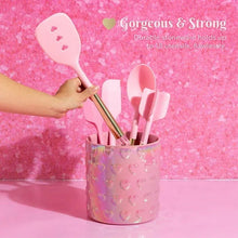 Pink iridescent ceramic utensil crock with embossed hearts holding cooking tools