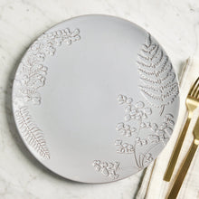 Gray stoneware dinner plate with raised leaf-and-flower relief, rounded rim