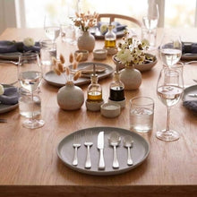 Hammered stainless steel flatware set displayed on a dining table