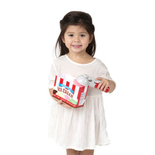Child holding the ice cream play set box with a white scoop