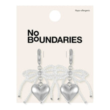 Silver-tone heart charm hoop earrings with bow-shaped bead strands on card
