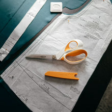 Orange-and-white fabric scissors with pointed blades and loop handles