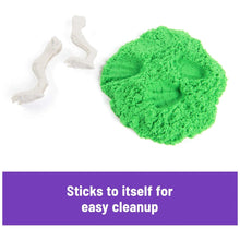 Green kinetic sand mound with white dinosaur skeleton mold pieces