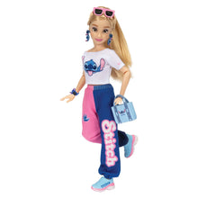 Disney Ily fashion doll wearing a white tee, pink-and-blue pants, and holding a tote bag.