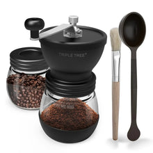 Black manual coffee grinder with coffee beans container, spoon, and measuring scoop