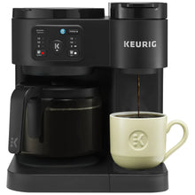 Black Keurig dual coffee maker with control panel and mug under brew spout