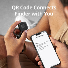Black key finder tag on a keyring, held near a smartphone
