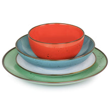 Red bowl on blue plate and green plate, all stoneware with speckled glaze and rims