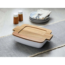White ceramic oven-to-table serving dish with acacia lid and wood board