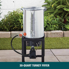 Aluminum turkey fryer pot with spigot and lid on black steel stand, outdoor use-ready
