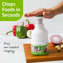 Food chopper on a wooden board, green base and clear container