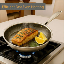 Nonstick fry pan with dark interior holding cooked fish and lemon slices
