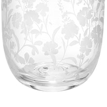 Clear glass tumbler with white floral pattern on curved sides, angled view