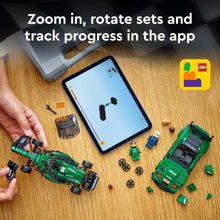 Two assembled green LEGO race cars with minifigures and a tablet showing app gameplay