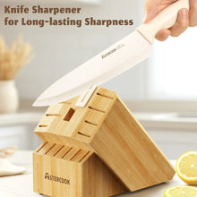 Kitchen knife with white handle and speckled blade stored in a wooden sharpener block