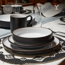 Ceramic dinnerware set stack with white bowls and black-rimmed plates
