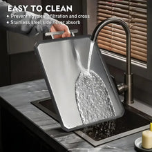 Double-sided cutting board positioned over a sink with water splash.