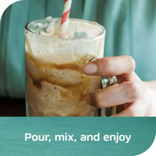 Iced coffee drink in a glass with cream-colored foam and a straw