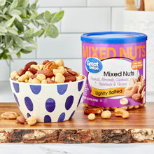 Mixed nuts tub with blue lid beside patterned bowl filled with nuts