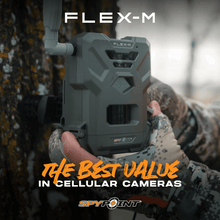 Gray trail camera with front sensor, held by hand in camouflage clothing