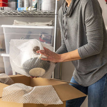 Small bubble cushioning wrap sheet being used to wrap items, white