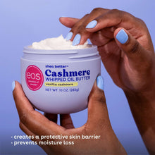Body butter jar held in hands with open lid, whipped cream on surface