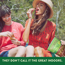 Crunchy cinnamon granola pouch held outdoors with Nature Valley branding
