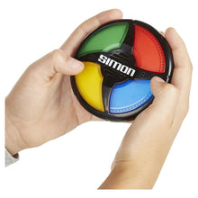 Handheld Simon game disc held in hands, black base with green, red, yellow, and blue buttons
