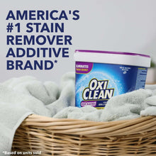 OxiClean odor blasters powder tub beside folded towels for stain remover additive claim