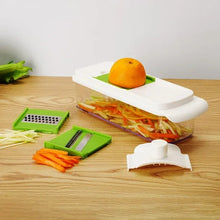 Multi-function mandoline slicer with green inserts and white housing holding an orange