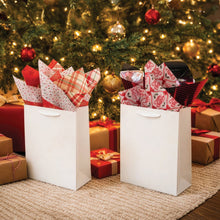 Christmas tissue paper in red, green and plaid patterns displayed in gift bags
