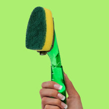 Dishwand refill head with green scouring pad on green handle held in hand