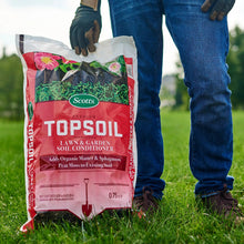 Person holding Scotts premium topsoil lawn & garden soil conditioner bag