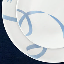 White glass plate with light blue ribbon vine motif along the rim and center