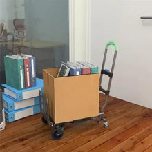 Folding hand truck with green handle carrying a cardboard box on wooden floor