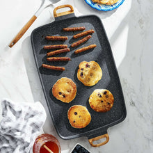 Charcoal speckle double griddle with six round pastries cooking on the surface