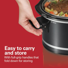 Black slow cooker with fold-down full-grip handles and food visible under lid