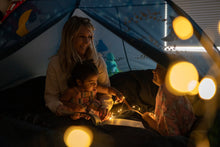 Blue kids bed tent interior with warm string lights and starry wall decals