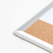 Whiteboard corner with gray edge and cork backing strip along the bottom