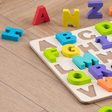 Wooden alphabet puzzle letters in mixed colors on a board with loose pieces
