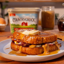 Country Crock Original buttery spread tub on a plate with sliced bread and spread