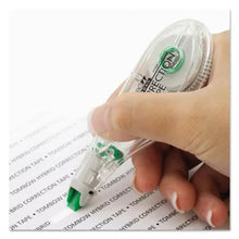 Hybrid correction tape applicator with green tip, hand holding the dispenser