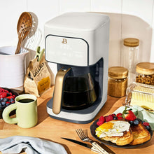 White 12-cup programmable coffee maker with gold-tone handle and black carafe