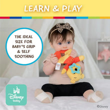 Baby holding a plush Winnie the Pooh sensory teether blanket with star detail