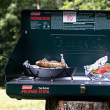 2-burner propane stove with open lid, sausages on grill grate, dark green
