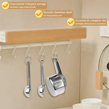 Stainless measuring cups and spoons hanging on a wall rack for storage