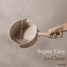 Taupe ceramic nonstick saucepan with wood handle, water pouring from spout
