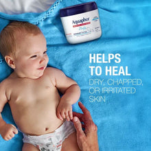 Aquaphor Baby healing ointment jar next to a baby on blue cloth